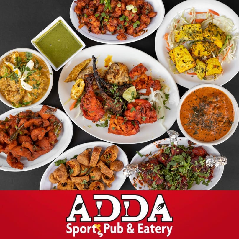 A vibrant spread of various Indian dishes including tandoori, curries, paneer, and fried appetizers.