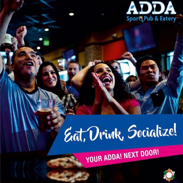Excited people cheering and celebrating in a lively sports pub.