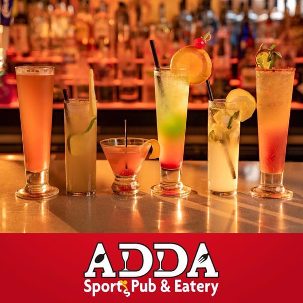 Six diverse, colorful cocktails with fruit and herb garnishes on a bar.